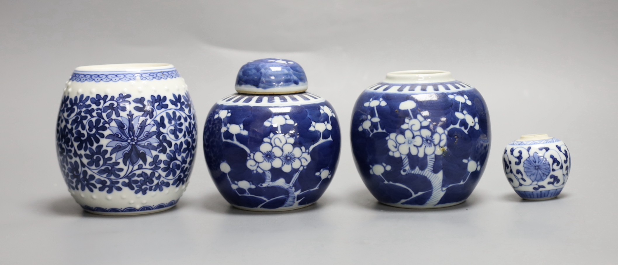 A pair of Chinese blue and white prunus jars, one with cover, a similar smaller jar and a ‘barrel’ jar